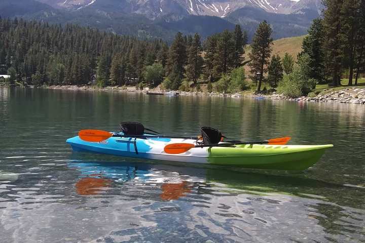 a group of people riding on the back of a boat in the water