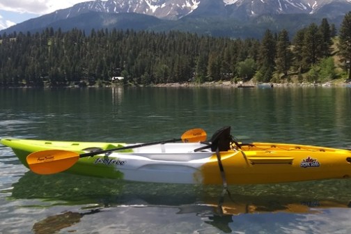 a small boat in a body of water with a mountain in the background