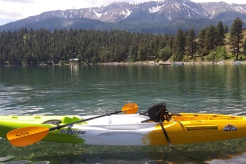 a small boat in a body of water with a mountain in the background