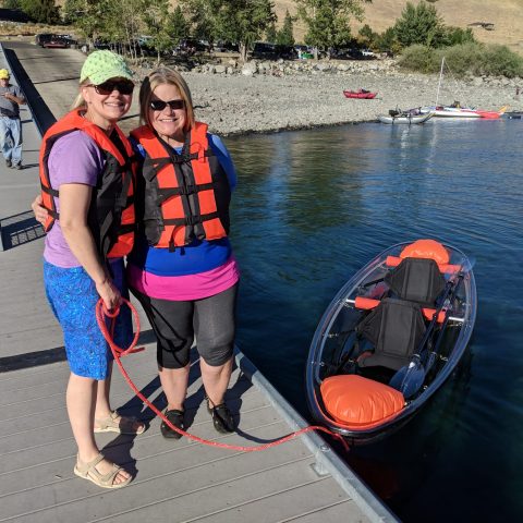 a group of people standing next to a boat in a body of water