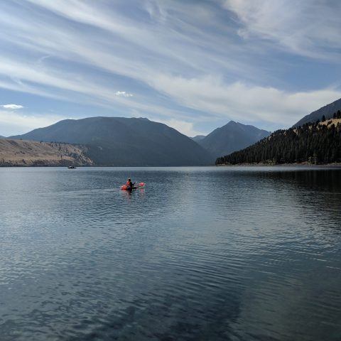 a boat on a body of water with a mountain in the background