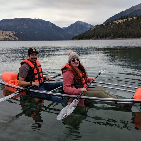 a group of people rowing a boat in a body of water