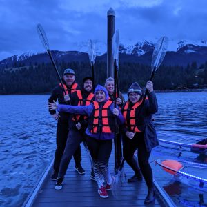 a group of people standing next to a body of water