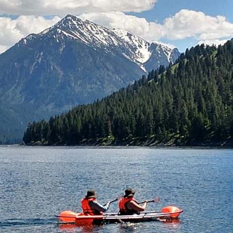 a group of people rowing a boat in the water