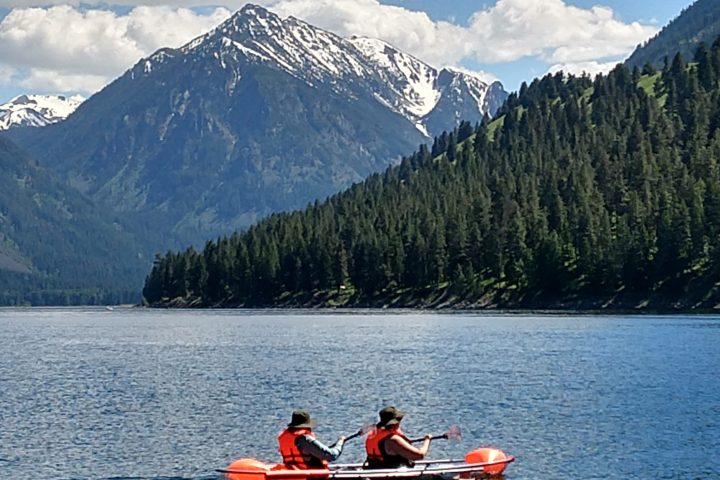 a group of people rowing a boat in the water
