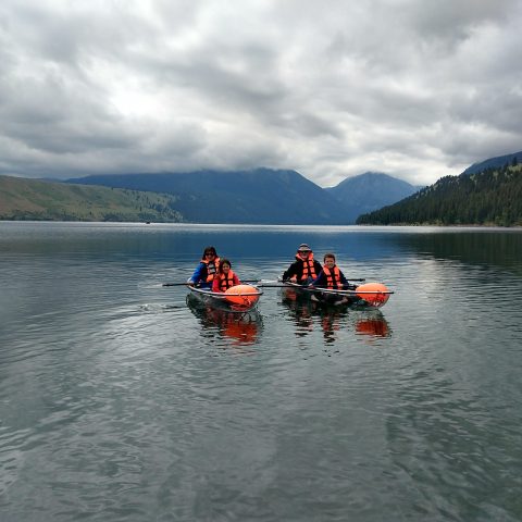 a group of people rowing a boat in a body of water