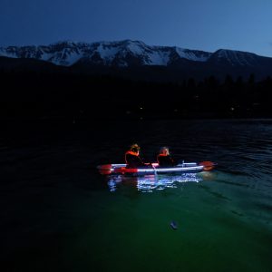a group of people rowing a boat in a body of water