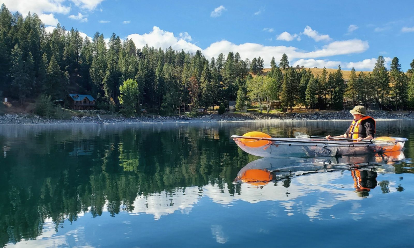 a small boat in a body of water surrounded by trees