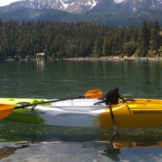 a small boat in a body of water with a mountain in the background